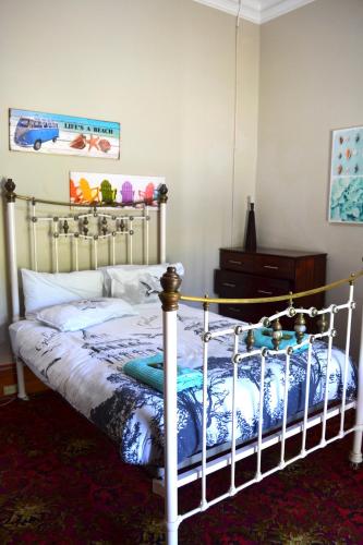 a bedroom with a bed and a dresser at Ithaca 1896 Manor in Busselton