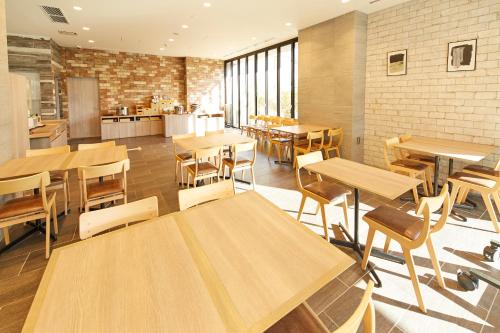a room with tables, chairs, and tables in it at hotel MONday Haneda Airport in Tokyo