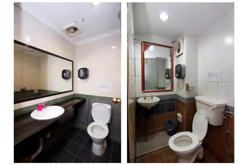a bathroom with two toilets and a sink and a mirror at Cosy Inn in Miri