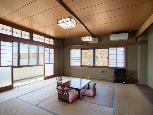a large room with a table and chairs and windows at Tabist Lakeside in Fujinami Yamanakako in Yamanakako