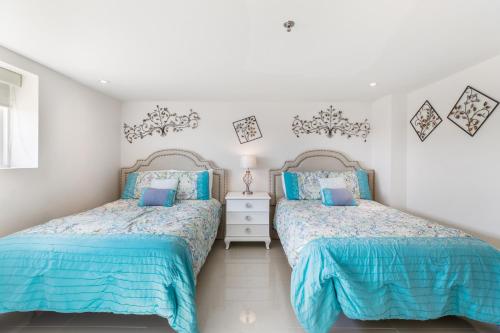 2 camas en un dormitorio con azul y blanco en Comfortable condo in beachfront resort Enjoy shared pools & jacuzzi, en South Padre Island