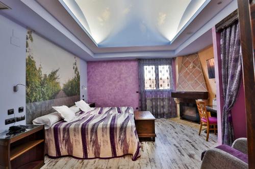 a bedroom with a bed and a table and a piano at Hotel SPA El Lagar de Isilla in La Vid y Barrios