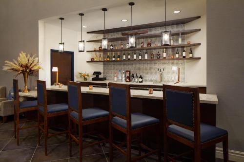 a kitchen with a bar with blue chairs at voco Saranac Lake NY - Waterfront by IHG in Saranac Lake