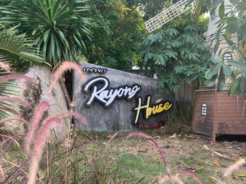 a sign in a garden with graffiti on it at Rayonghouse Resort in Rayong