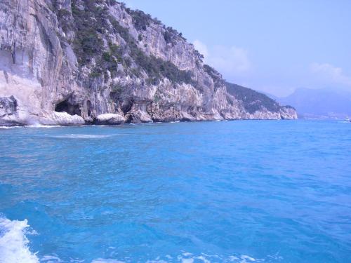 a large body of blue water next to a mountain at B&B Luce Viola in Dorgali