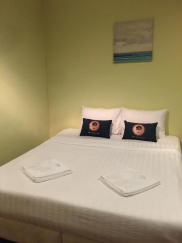 a bed with two pictures on the pillows on it at RoomQuest Amphawa Floating Market in Amphawa