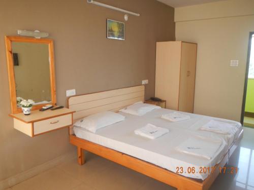 a bedroom with a bed with a mirror and a dresser at HOTEL RUKMINI in Vasco Da Gama