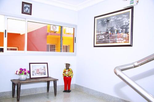 a statue of a woman standing next to a table at Cypa Hotel in Abidjan