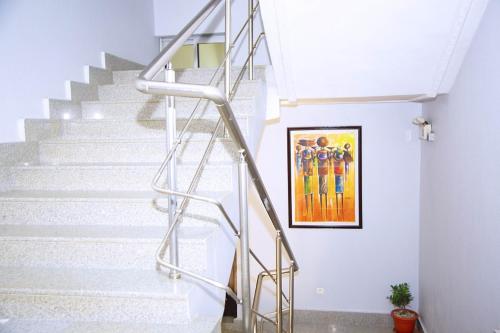 a metal staircase in a home with a painting on the wall at Cypa Hotel in Abidjan