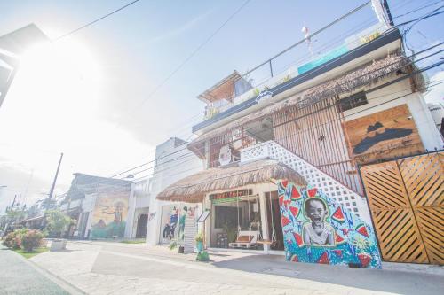um edifício com um mural ao lado em Straw Hat Hostel & Rooftop Bar em Tulum