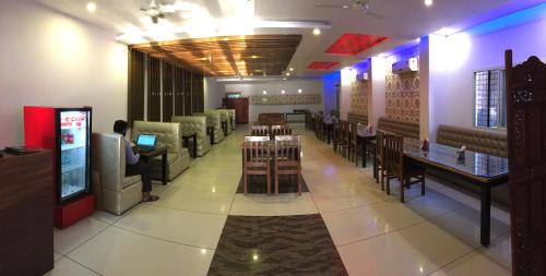 a restaurant with tables and chairs and a video game at Hotel Trihari in Rishīkesh