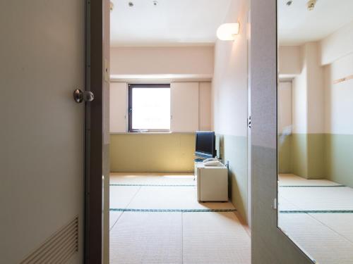 an empty room with a door open to an office at Tabist Hotel Tetora Kitakyushu in Kitakyushu