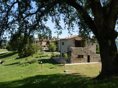 a stone building in a field with a tree at Sasseta Alta in Scansano