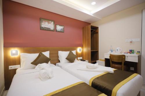 Un pat sau paturi într-o cameră la The Avenue Hotel Ballygunge