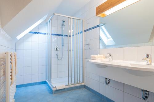 W łazience znajduje się szklana kabina prysznicowa i umywalka. w obiekcie Gasthaus-Pension Zum Kreuz w mieście Stühlingen