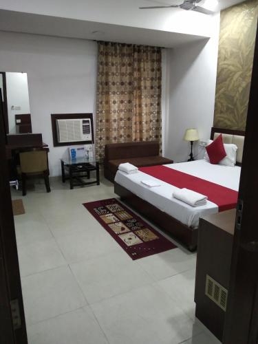 a bedroom with a large bed and a living room at Hotel Popular in Amritsar