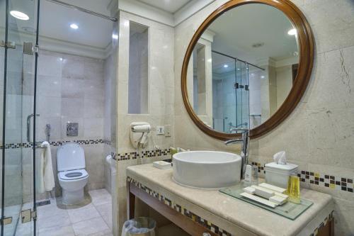 y baño con lavabo, espejo y aseo. en Zaver Pearl Continental, Gwadar, en Gwādar
