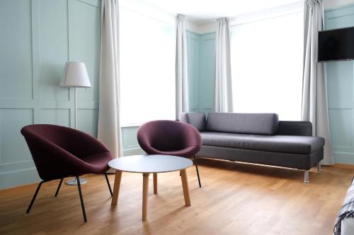 a living room with two chairs and a couch at Hotel Jakob in Rapperswil-Jona