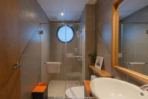 a bathroom with a glass shower and a sink at Mojzo Inn Boutique Hotel in Nha Trang