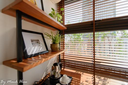 a living room with a window with blinds on it at Mojzo Inn Boutique Hotel in Nha Trang