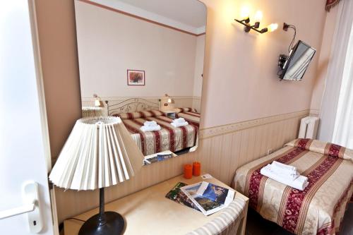 1 Schlafzimmer mit 2 Betten, einer Lampe und einem Spiegel in der Unterkunft B&B MediNaples in Neapel