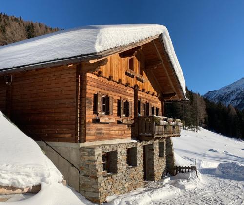 a log cabin with snow on the roof at Ferienhof Oberer Gollmitzer in Heiligenblut