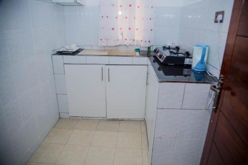 a small kitchen with white cabinets and a counter top at Sheratton Beach Villagio in Mombasa