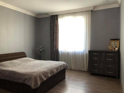 1 dormitorio con 1 cama, vestidor y ventana en Our house en Borjomi