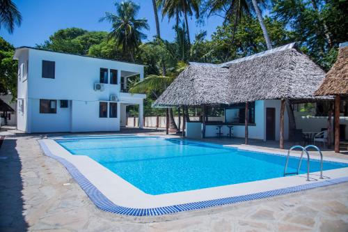 a swimming pool in front of a villa at Sheratton Beach Villagio in Mombasa