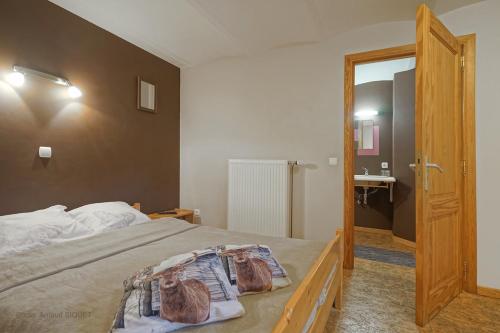 a bedroom with a bed and a door to a bathroom at ferme st martin in Manhay