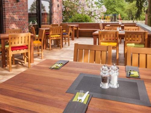 a restaurant with a wooden table and chairs and tables and chairs at Hotel-Restaurant Zur Linde in Secklendorf