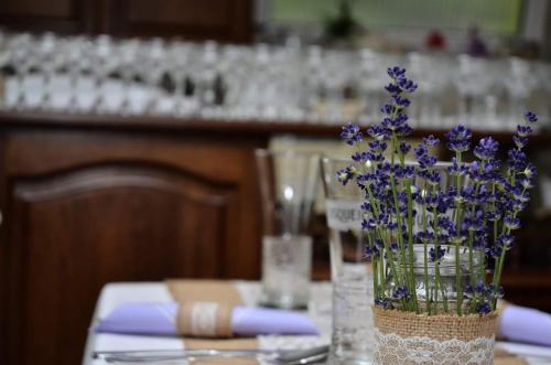 a vase filled with purple flowers on a table at Gránit Villa in Balatonszárszó