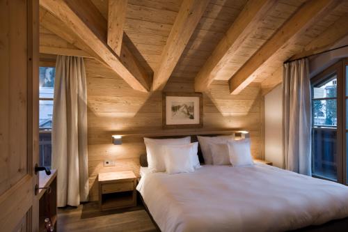 een slaapkamer met een groot bed en een houten plafond bij Chalet Corvara in Corvara in Badia