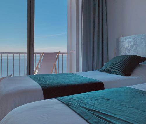 two beds in a room with a view of the ocean at Il Tramonto in Calvi