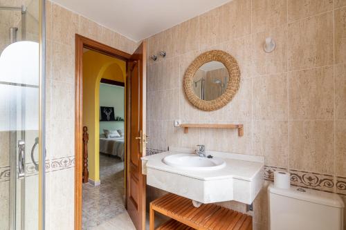 a bathroom with a sink and a mirror on the wall at Adosado El Perenquen in Agaete