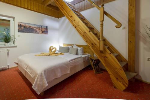 Pension Erdmann Garni في هيرينجسدورف: غرفة نوم بسرير مع درج خشبي