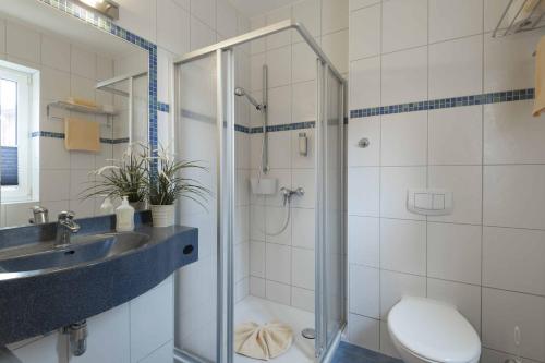 a bathroom with a shower and a sink and a toilet at Pension Erdmann Garni in Heringsdorf