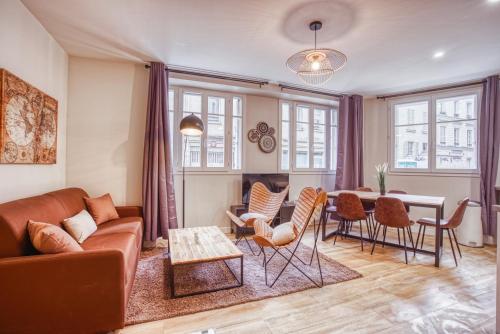 un salon avec un canapé, une table et des chaises dans l'établissement Vernezza, F3 à deux pas de Montparnasse, à Paris