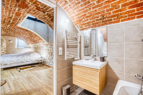 La salle de bains est pourvue d'un lit dans un mur en briques. dans l'établissement Vernezza, F3 à deux pas de Montparnasse, à Paris