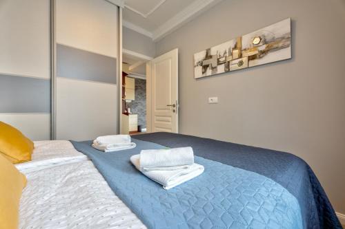 a bedroom with a blue bed with towels on it at Adonis 201 in Zlatibor