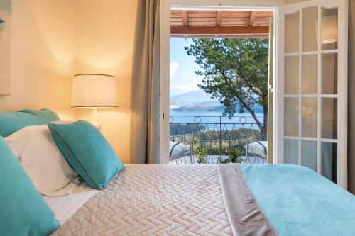 a bedroom with a bed with a view of the ocean at Villa Leondari by Rodostamo Collection in Ágios Stéfanos