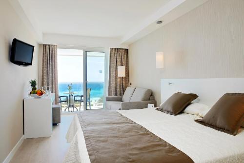 a bedroom with a bed and a view of the ocean at Hipotels Hipocampo - Adults Only in Cala Millor