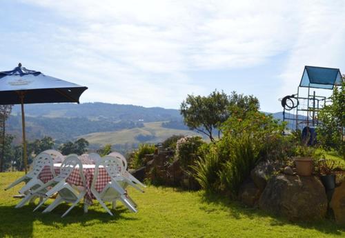 a table and chairs and an umbrella on a field at Edi's B&B and Bratwurst Sausage Restaurant in Balgowan