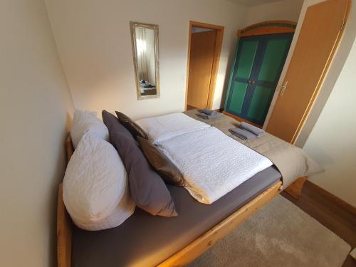 a bedroom with a bed with pillows and a mirror at Pension Reinhardshäusle in Reinhardshausen