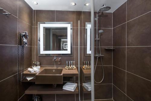 a bathroom with a sink, toilet and mirror at Novotel Moscow City in Moscow