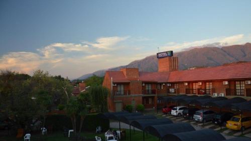 a hotel with cars parked in a parking lot at Hotel Valle Del Sol in Merlo