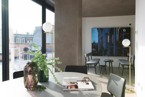 a dining room with a table and chairs and a large window at Milan Eleven by Brera Apartments in Milan