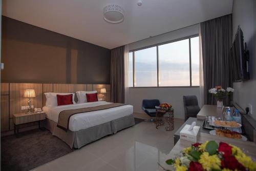 Fortis Hotel Fujairah في الفجيرة: فندق غرفه بسرير وصاله