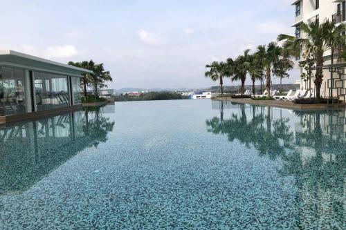 a large pool of water with palm trees and a building at HomestayBABA close to UKM, GMI, & more ! in Kajang