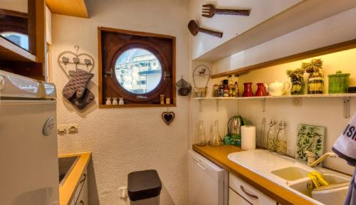 une petite cuisine avec un évier et une fenêtre dans l'établissement 4807 Appt, Chamonix Sud, Terrasse Mont Blanc, à Chamonix-Mont-Blanc